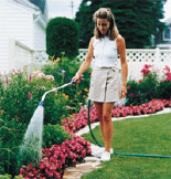 Watering the garden with a spray head watering wand